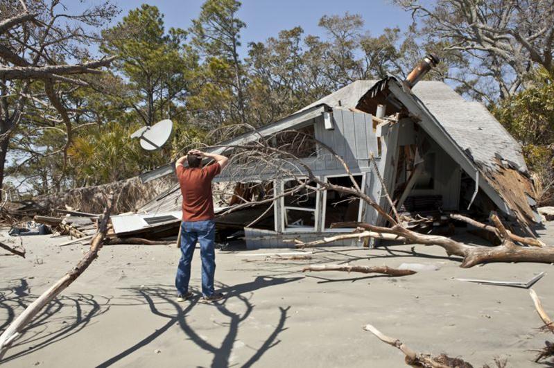 man grieving his destroyed home